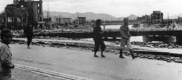 Local residents walk past the gutted Hiroshima Prefectural Industrial Promotion Hall - Sputnik International