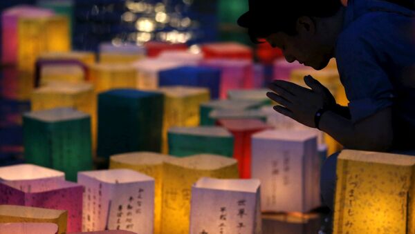 A man prays after releasing a paper lantern on the Motoyasu river facing the Atomic Bomb Dome in remembrance of atomic bomb victims on the 70th anniversary of the bombing of Hiroshima, western Japan, August 6, 2015. - Sputnik International