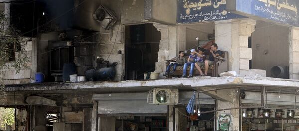 Residents sit on a couch on a balcony of a damaged building in Aleppo's al-Shaar neighboirhood, Syria, August 1, 2015. - Sputnik International