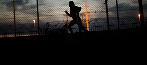 A migrant runs after crossing a fence as he attempts to access the Channel Tunnel, in Calais, northern France, Monday, Aug. 3, 2015. A migrant runs after crossing a fence as he attempts to access the Channel Tunnel, in Calais, northern France, Monday, Aug. 3, 2015. - Sputnik International