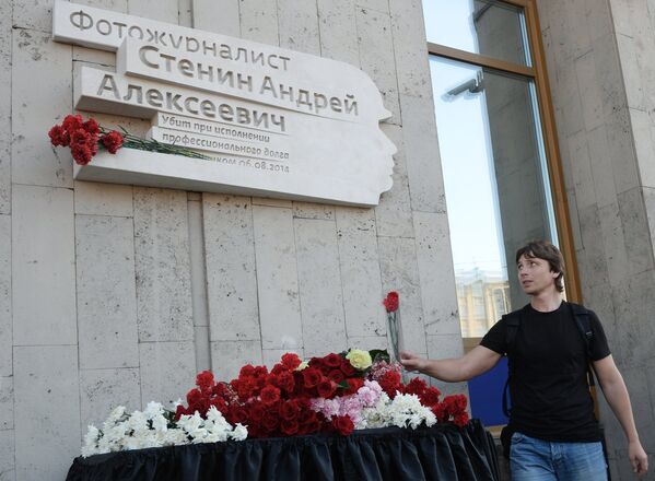 A journalist lays flowers by a plaque in memory of Rossiya Segodnya photo journalist Andrei Stenin, who died on August 6, 2014 in Ukraine while performing his professional dut - Sputnik International