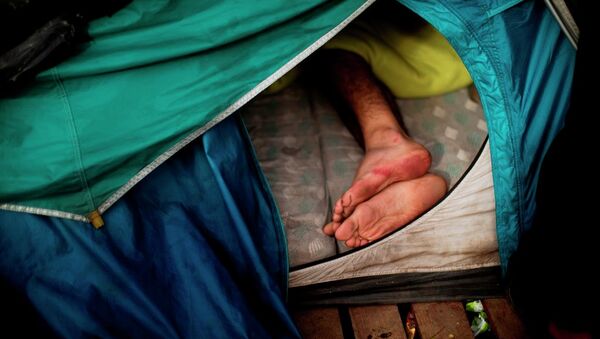 A migrant sleeps inside a tent at a camp set near Calais, northern France, Wednesday, Aug. 5, 2015. - Sputnik International