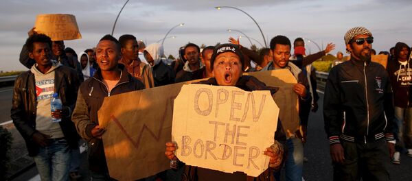 African migrants shout slogans during a protest on a motorway in Calais, France African migrants shout slogans during a protest on a motorway in Calais, France - Sputnik International
