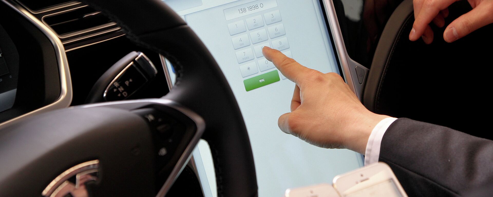 A guest experiences a Tesla car at a car handover ceremony in Shanghai as American electric carmaker Tesla Motors delivers their Model S carsto its first buyers in China on April 23, 2014 - Sputnik International, 1920, 04.05.2022