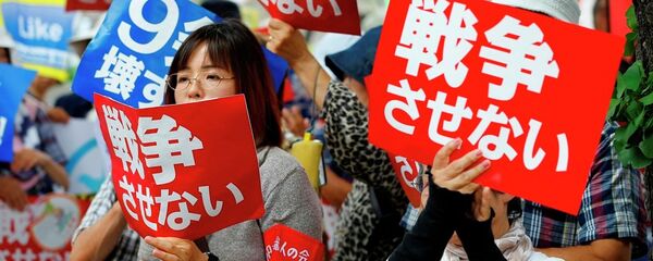 Protesters hold anti-war placards in front of the National Diet building during a rally in Tokyo - Sputnik International