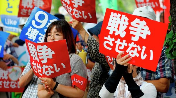 Protesters hold anti-war placards in front of the National Diet building during a rally in Tokyo - Sputnik International