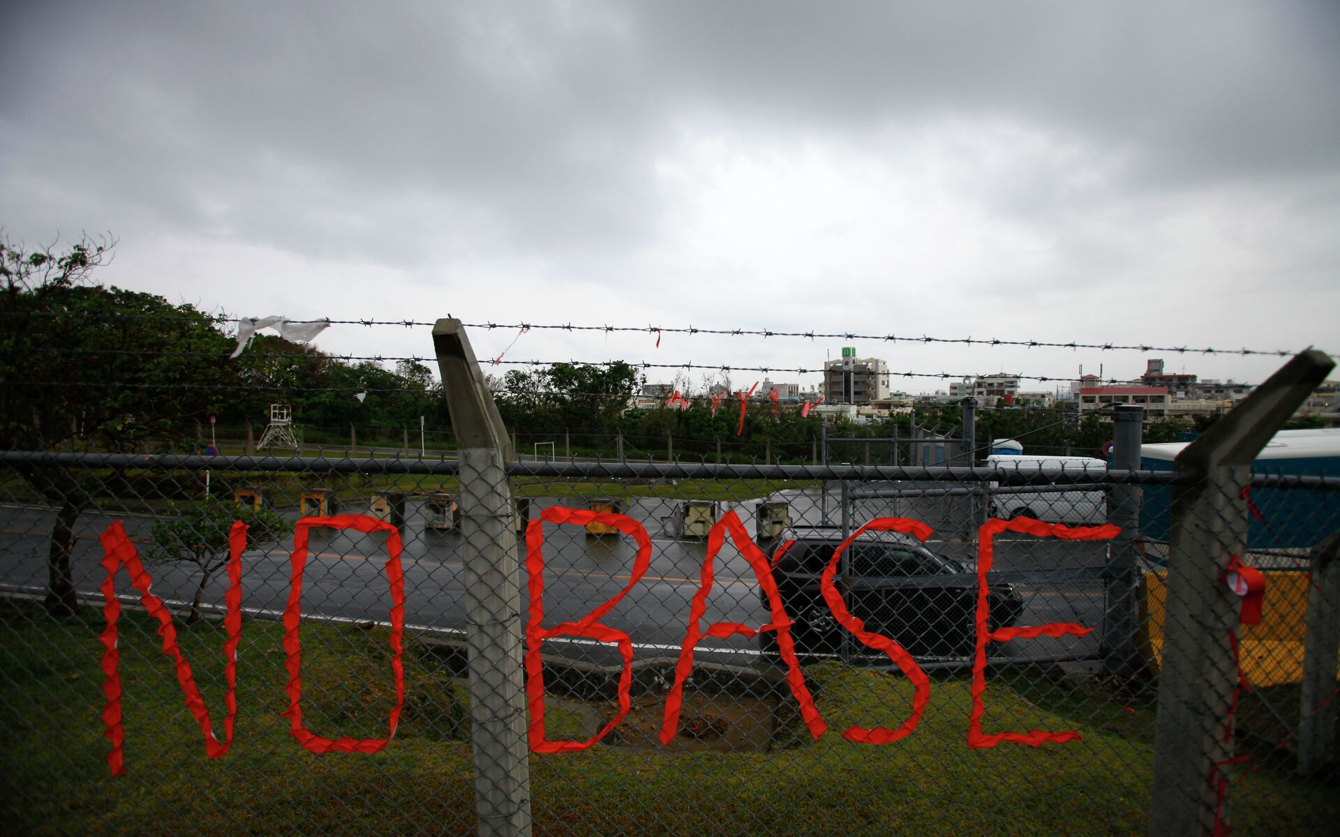 A slogan against the base is displayed on the fence enclosed U.S. Marine Corps Futenma Air Station in Ginowan on southern Japanese islands of Okinawa. File photo - Sputnik International, 1920, 31.07.2024