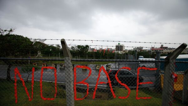 A slogan against the base is displayed on the fence enclosed U.S. Marine Corps Futenma Air Station in Ginowan on southern Japanese islands of Okinawa. File photo - Sputnik International