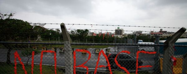 A slogan against the base is displayed on the fence enclosed U.S. Marine Corps Futenma Air Station in Ginowan on southern Japanese islands of Okinawa. File photo - Sputnik International