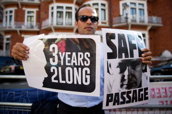 A supporter of Wikileaks founder Julian Assange holds banners outside the Ecuadorian embassy in London as he marks three years since Assange claimed asylum in the embassy on June 19, 2015. A supporter of Wikileaks founder Julian Assange holds banners outside the Ecuadorian embassy in London as he marks three years since Assange claimed asylum in the embassy on June 19, 2015. - Sputnik International