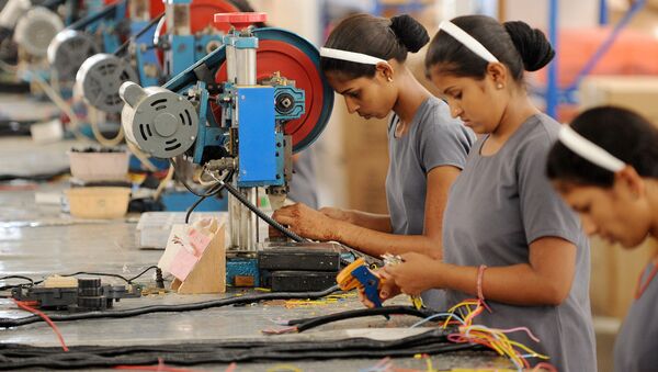 Indian women work at the electrical wiring section of the OREVA E Bike manufacturing facility near Samakhiali of Kutch district, some 240 kms from Ahmedabad on May 24, 2012 - Sputnik International