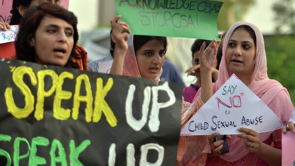 Pakistani rights activists carry placards as they shout slogans during a protest against a child sex abuse scandal in Islamabad on August 10, 2015 - Sputnik International