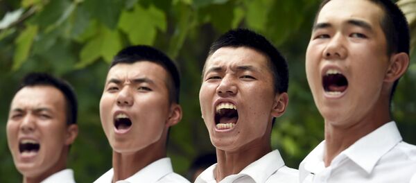 Paramilitary policemen and members of a gun salute team shout slogans as they stand in formation during a training session for a military parade to mark the 70th anniversary of the end of the World War Two, at a military base in Beijing, China, August 1, 2015 - Sputnik International