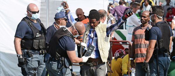 A police officer uses and hand held metal detector to check a man as he disembark from the patrol vessel Fiorillo of the Italian Coast Guard after it arrived in the port of Pozzallo on August 7, 2015 after saving some 387 migrants in the Sicilian Channel A police officer uses and hand held metal detector to check a man as he disembark from the patrol vessel Fiorillo of the Italian Coast Guard after it arrived in the port of Pozzallo on August 7, 2015 after saving some 387 migrants in the Sicilian Channel - Sputnik International