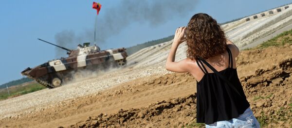 A spectator takes photos of an infantry combat vehicle of Venezuela's team during the Suvorov Onslaught competition of BMP-2 infantry combat vehicles held as part of the International Army Games 2015. - Sputnik International