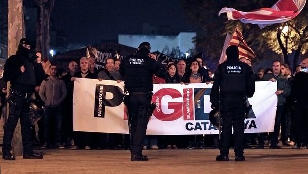 Policemen stand in front of supporters of the anti-Islam group 'Pegida' (Patriotic Europeans Against The Islamization Of The West) during a demonstration in L' Hospitalet del Llobregat on March 11, 2015 - Sputnik International