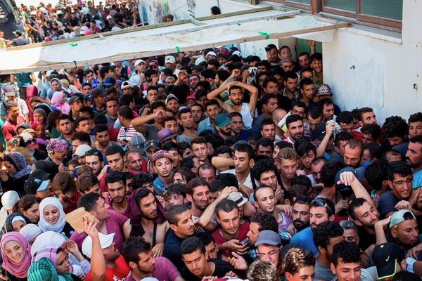 Syrian migrants and refugees gather at a makeshift migrant detention center at Kos' abandoned football stadium after crossing from Turkey, at the southeastern island of Kos, Greece, Wednesday, Aug. 12, 2015. Syrian migrants and refugees gather at a makeshift migrant detention center at Kos' abandoned football stadium after crossing from Turkey, at the southeastern island of Kos, Greece, Wednesday, Aug. 12, 2015. - Sputnik International