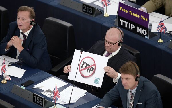 Members of the European Parliament take part in a voting session as they hold signs against the Transatlantic Trade and Investment Partnership (TTIP), on June 10, 2015, in the European Parliament in Strasbourg, eastern France - Sputnik International