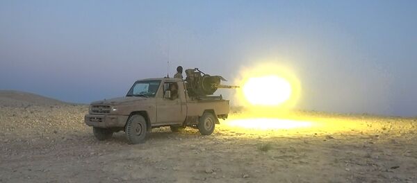 This picture released on July 12, 2015 by the Rased News Network, a Facebook page affiliated with Islamic State militants, shows an Islamic State militant fires a heavy weapon during a battle against Syrian government forces, in Homs province, Syria - Sputnik International