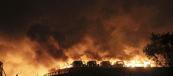 Vehicles are seen burning after blasts at Binhai new district in Tianjin municipality, China, August 13, 2015 - Sputnik International