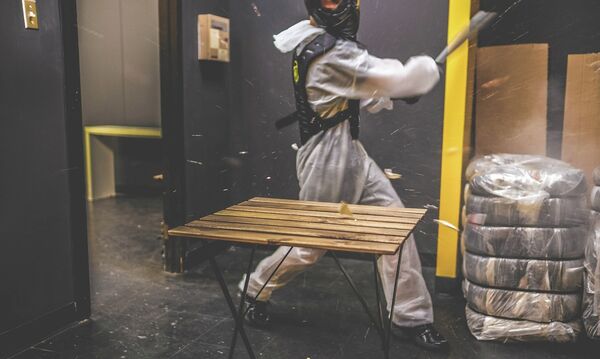 A customer uses a baseball bat to smash a household item in the Rage Room at Battle Sports in Toronto, Canada. - Sputnik International