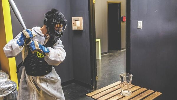 A customer prepares to swing a baseball bat at a vase in the Rage Room at Battle Sports in Toronto, Canada. - Sputnik International