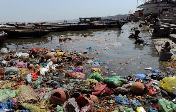 Indian scavengers look for coins and other valuable items from among the offerings of devotees in the Ganges at Varanasi Indian scavengers look for coins and other valuable items from among the offerings of devotees in the Ganges at Varanasi - Sputnik International