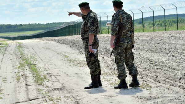 Ukrainian border guards patrol on July 2, 2015 along the barbed wire fence on the Senkivka border post, around 200 kilometres (125 miles) north of the Ukrainian capital Kiev. - Sputnik International