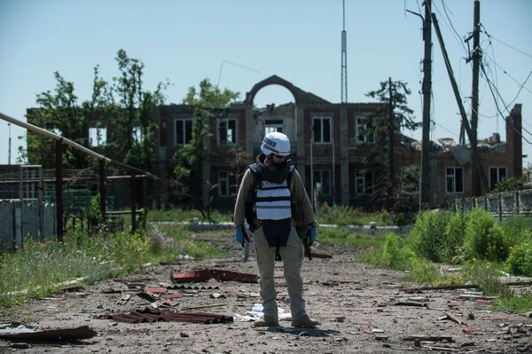 An OSCE monitor checks the territory for mines during a patrol in Shyrokyne, Donetsk region eastern Ukraine, Saturday, July 4, 2015 An OSCE monitor checks the territory for mines during a patrol in Shyrokyne, Donetsk region eastern Ukraine, Saturday, July 4, 2015 - Sputnik International