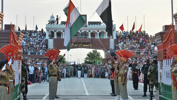 Indian and Pakistani flags are lowered during a daily retreat ceremony at the India-Pakistan joint border check post of Attari-Wagah near Amritsar, India, Tuesday, July 21, 2015 - Sputnik International