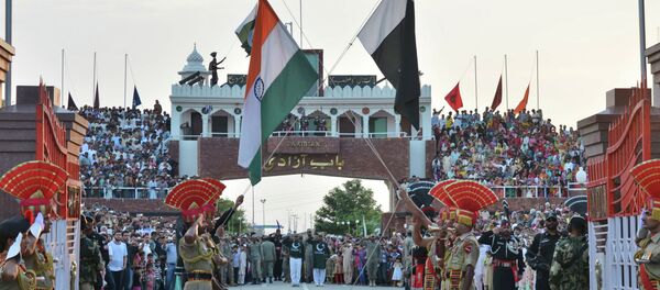 Indian and Pakistani flags are lowered during a daily retreat ceremony at the India-Pakistan joint border check post of Attari-Wagah near Amritsar, India, Tuesday, July 21, 2015 - Sputnik International