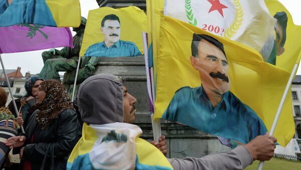 Demonstrators wave flags bearing pictures of jailed Kurdish rebel leader Abdullah Ocalan during a protest against the Turkish government in Brussels on July 28, 2015 - Sputnik International