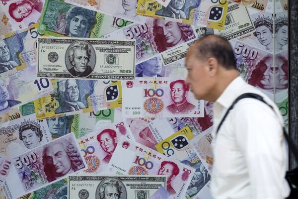 A man walks past an advertisement promoting China's renminbi (RMB) or yuan, U.S. dollar and Euro exchange services at foreign exchange store in Hong Kong, China, August 13, 2015 - Sputnik International