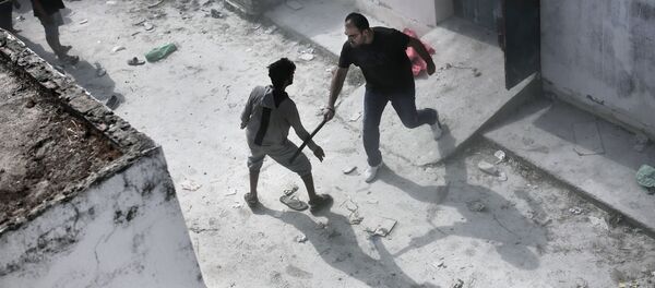 A policeman hits a migrant with a truncheon during a registration procedure at the stadium on the Greek island of Kos on August 11, 2015. A policeman hits a migrant with a truncheon during a registration procedure at the stadium on the Greek island of Kos on August 11, 2015. - Sputnik International