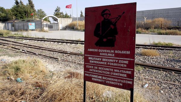 A Turkish military warning sign, with the closed Karkamis border gate in the background, is pictured in Karkamis, bordering with the Islamic State-held Syrian town of Jarablus, in Gaziantep province, Turkey - Sputnik International