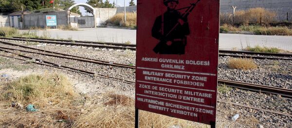 A Turkish military warning sign, with the closed Karkamis border gate in the background, is pictured in Karkamis, bordering with the Islamic State-held Syrian town of Jarablus, in Gaziantep province, Turkey - Sputnik International