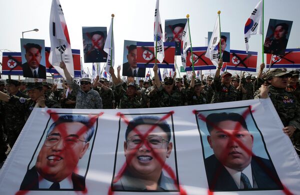 Members of the Korean Disabled Veterans Association by Agent Orange in Vietnam War, shout slogans with a banner showing defaced images of North Korean leader Kim Jong Un, right, late his father Kim Jong Il, center, and Kim Il Sung, the late founder of North Korea, during a rally denouncing North Korea. - Sputnik International
