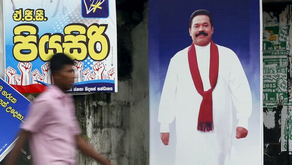 A man walks past a poster of Sri Lanka's former president Mahinda Rajapaksa ahead of a general election, in Galle August 14, 2015 - Sputnik International