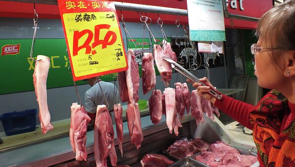 A customer selects the pieces of pork, supplied by Shuanghui, which controls China's largest meat-processing company, at a supermarket in Yichang, central China's Hubei province - Sputnik International