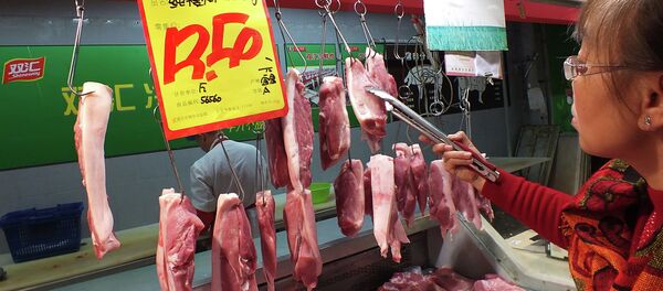 A customer selects the pieces of pork, supplied by Shuanghui, which controls China's largest meat-processing company, at a supermarket in Yichang, central China's Hubei province - Sputnik International