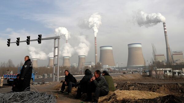Chinese workers take a break in front of the cooling towers of a coal-fired power plant in Dadong, Shanxi province, China - Sputnik International