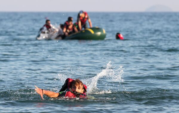Migrants and refugees, one of them swims, arrive after crossing from Turkey, at the southeastern island of Kos, Greece, Monday, Aug. 17, 2015 Migrants and refugees, one of them swims, arrive after crossing from Turkey, at the southeastern island of Kos, Greece, Monday, Aug. 17, 2015 - Sputnik International
