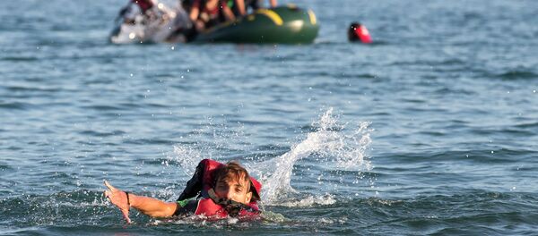 Migrants and refugees, one of them swims, arrive after crossing from Turkey, at the southeastern island of Kos, Greece, Monday, Aug. 17, 2015 Migrants and refugees, one of them swims, arrive after crossing from Turkey, at the southeastern island of Kos, Greece, Monday, Aug. 17, 2015 - Sputnik International