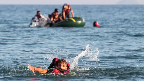 Migrants and refugees, one of them swims, arrive after crossing from Turkey, at the southeastern island of Kos, Greece, Monday, Aug. 17, 2015 - Sputnik International