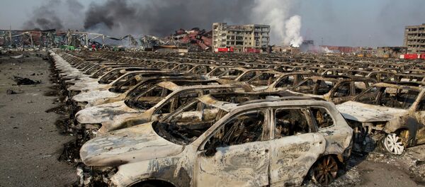 Smoke billows from the site of an explosion that reduced a parking lot filled with new cars to charred remains at a warehouse in northeastern China's Tianjin municipality, Thursday, Aug. 13, 2015 Smoke billows from the site of an explosion that reduced a parking lot filled with new cars to charred remains at a warehouse in northeastern China's Tianjin municipality, Thursday, Aug. 13, 2015 - Sputnik International