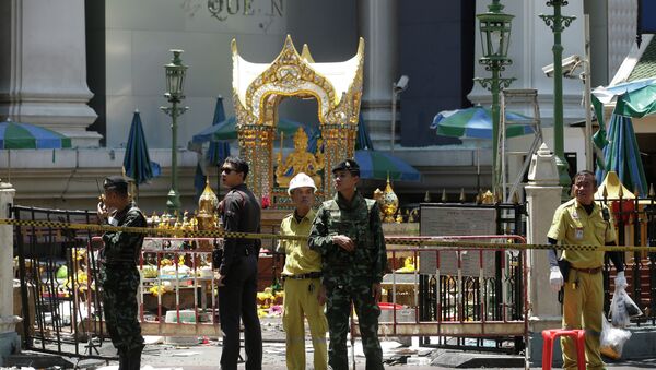 Police, soldiers, and other officials work near the statue of Phra Phrom, the Thai interpretation of the Hindu god Brahma, at the Erawan Shrine at Rajprasong intersection the day after an explosion in Bangkok, Thailand, Tuesday, Aug. 18, 2015 - Sputnik International