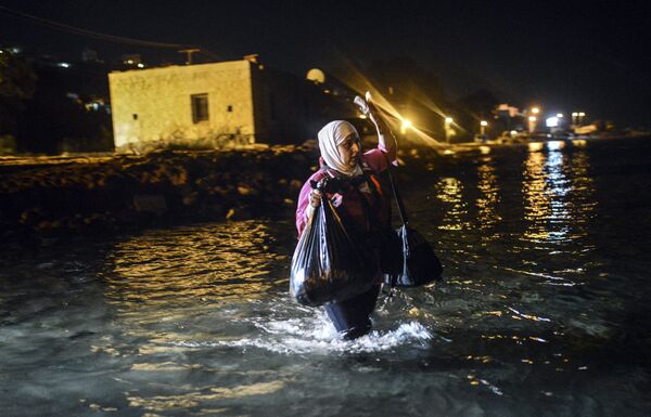 A migrant walks to a boat to reach the Greek island of Kos on early August 18, 2015. A migrant walks to a boat to reach the Greek island of Kos on early August 18, 2015. - Sputnik International