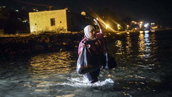 A migrant walks to a boat to reach the Greek island of Kos on early August 18, 2015. - Sputnik International