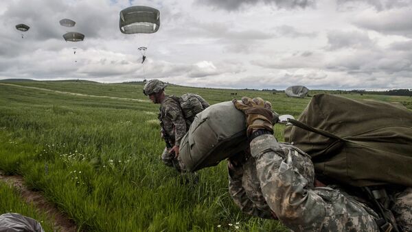 US para-troopers of the Army's 4th 25 Infantry Brigade Combat Team (Airborne), part of the NATO-led peacekeeping mission in Kosovo (KFOR) jump with parachute during a military drill near the village of Ramjan on May 27, 2015 - Sputnik International