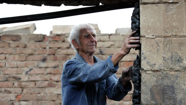 A man by his house, which was destroyed by a Ukrainian military artillery attack on Donetsk's Kuibyshevsky District - Sputnik International